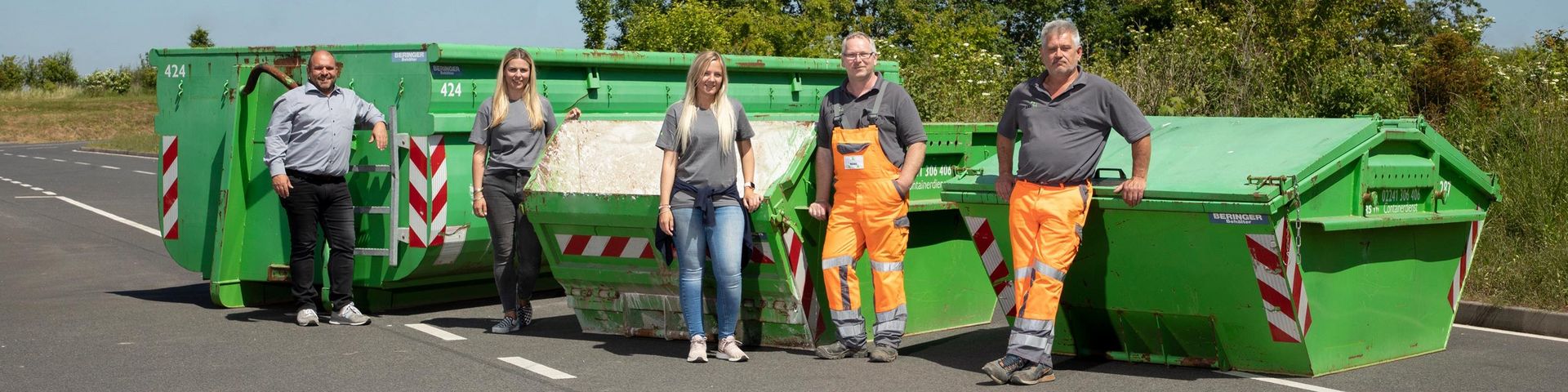 Mitarbeitende stehen vor Containern